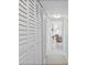 Hallway with white louvered closet doors leading into a naturally lit sitting room with light wood-look floors at 10355 Paradise Blvd # 412, Treasure Island, FL 33706