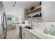 Modern kitchen with white countertops, stainless steel appliances, and open shelving at 10355 Paradise Blvd # 412, Treasure Island, FL 33706