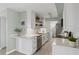 Bright kitchen with white cabinets, stone countertops, stainless steel appliances, and decorative shelving at 10355 Paradise Blvd # 412, Treasure Island, FL 33706