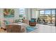 Bright and airy living room with casual furnishings and a sliding door to outdoor patio with water views at 10355 Paradise Blvd # 412, Treasure Island, FL 33706