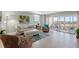Bright and airy living room with casual furnishings and a sliding door to outdoor patio with water views at 10355 Paradise Blvd # 412, Treasure Island, FL 33706