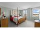 Spacious main bedroom with four-poster bed, large windows, and scenic views of the nearby coastline at 10355 Paradise Blvd # 412, Treasure Island, FL 33706