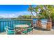 Outdoor dining area with grills, a table, chairs, and water view at 10355 Paradise Blvd # 412, Treasure Island, FL 33706