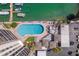 Aerial view of a pool surrounded by lounge chairs and lush greenery, with a dock and boats nearby at 10355 Paradise Blvd # 412, Treasure Island, FL 33706