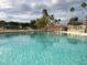 Sparkling outdoor pool surrounded by chairs and tropical landscaping with a nearby gazebo at 10355 Paradise Blvd # 412, Treasure Island, FL 33706