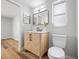 Bathroom boasts a wooden vanity with marble countertop, black fixtures, and tile flooring at 10825 Oakdale Ave, Port Richey, FL 34668