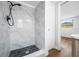 Updated shower with stylish gray tile, black fixtures, and sleek, modern design at 10825 Oakdale Ave, Port Richey, FL 34668