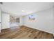 Bright bedroom featuring wood floors, white walls, and sliding door access to an enclosed porch at 10825 Oakdale Ave, Port Richey, FL 34668
