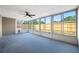Enclosed sunroom featuring a ceiling fan and clear views of the fenced backyard at 10825 Oakdale Ave, Port Richey, FL 34668