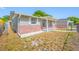 Corner view of this updated home, showcasing the brick accents, manicured garden, and side yard at 10825 Oakdale Ave, Port Richey, FL 34668