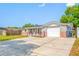 Inviting home featuring a gray facade with brick accents, a garage, and a long driveway at 10825 Oakdale Ave, Port Richey, FL 34668