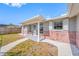 Close-up of the front entrance, showcasing the brickwork, columns, and well-lit porch at 10825 Oakdale Ave, Port Richey, FL 34668