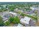 Elevated view of a condo community with a pool and tennis courts, encircled by roads and greenery at 1100 E Bay Dr # 60, Largo, FL 33770
