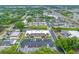 Wide aerial perspective of condos nestled among trees with nearby roads, parking, and commercial areas at 1100 E Bay Dr # 60, Largo, FL 33770