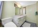 Bright bathroom with a toilet, vanity, large mirror, and blue floor tiles at 1100 E Bay Dr # 60, Largo, FL 33770