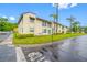 A tan two-story condo with green lawns and palm trees at 1100 E Bay Dr # 60, Largo, FL 33770