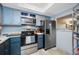 A kitchen showcasing blue cabinets, stainless steel appliances, and an above range microwave at 1100 E Bay Dr # 60, Largo, FL 33770
