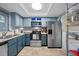 A blue kitchen showcasing stainless steel appliances, cabinetry, and white countertops at 1100 E Bay Dr # 60, Largo, FL 33770