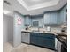 Kitchen featuring stainless steel dishwasher, neutral countertops, and blue lower cabinets at 1100 E Bay Dr # 60, Largo, FL 33770