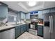 Kitchen featuring stainless steel appliances, neutral countertops, and light blue cabinets at 1100 E Bay Dr # 60, Largo, FL 33770