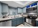 Kitchen with stainless steel appliances, light blue cabinets, and neutral countertops at 1100 E Bay Dr # 60, Largo, FL 33770