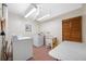 Community laundry room featuring multiple machines, utility sink, folding table, and laminate paneled door at 1100 E Bay Dr # 60, Largo, FL 33770
