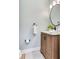 Modern bathroom with a wood vanity, round mirror, and stylish fixtures at 11320 Lazy Hickory Ln, Tampa, FL 33635