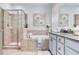 This elegant bathroom features a glass shower, a soaking tub, and a blue vanity with granite countertops at 11320 Lazy Hickory Ln, Tampa, FL 33635