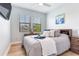 This bedroom boasts neutral walls, hardwood floors, a bed, a wall-mounted TV, and a bright window at 11320 Lazy Hickory Ln, Tampa, FL 33635