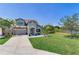 Beautiful home featuring a manicured front lawn and picturesque lake view at 11320 Lazy Hickory Ln, Tampa, FL 33635