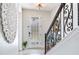 Close up of foyer with decorative wrought iron staircase railing, patterned rug and decorative wall art at 11320 Lazy Hickory Ln, Tampa, FL 33635