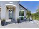 Charming home featuring a blue front door, covered porch, and potted plants for a welcoming entrance at 11320 Lazy Hickory Ln, Tampa, FL 33635