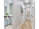 Charming hallway with hardwood floors connects a powder room with a granite vanity to other rooms at 11320 Lazy Hickory Ln, Tampa, FL 33635