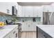 Bright kitchen features white cabinetry, stainless appliances, a marble countertop, and blue tile backsplash at 11320 Lazy Hickory Ln, Tampa, FL 33635