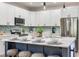 Bright kitchen features a spacious marble island, stainless appliances, and a stylish blue backsplash at 11320 Lazy Hickory Ln, Tampa, FL 33635