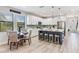 Open concept kitchen and dining area features white cabinets, an island, and stainless steel appliances at 11320 Lazy Hickory Ln, Tampa, FL 33635