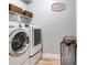 Clean laundry room with front-load washer and dryer and overhead storage shelves at 11320 Lazy Hickory Ln, Tampa, FL 33635