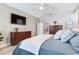 This serene main bedroom boasts hardwood floors, a ceiling fan, and stylish dressers with a wall-mounted television at 11320 Lazy Hickory Ln, Tampa, FL 33635