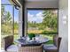 Outdoor dining and serene lake views from this cozy screened lanai at 11320 Lazy Hickory Ln, Tampa, FL 33635