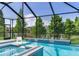 Luxury pool with waterfall feature, surrounded by lush greenery and a screened enclosure at 11320 Lazy Hickory Ln, Tampa, FL 33635