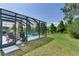 Screened lanai with a pool, relaxing lounge chairs, and a picturesque lake view at 11320 Lazy Hickory Ln, Tampa, FL 33635