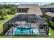 Aerial view of a screened in pool and spa in a backyard with a lake and trees in the background at 11320 Lazy Hickory Ln, Tampa, FL 33635