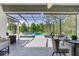 Relaxing screened patio featuring a pool, jacuzzi, outdoor seating, and serene lake views at 11320 Lazy Hickory Ln, Tampa, FL 33635