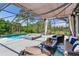 Relaxing outdoor living space with a screened-in pool, spa, and comfortable seating with lake views at 11320 Lazy Hickory Ln, Tampa, FL 33635
