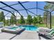 Beautiful screened pool and spa with lounge chairs overlooking a tranquil lake setting at 11320 Lazy Hickory Ln, Tampa, FL 33635