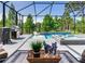 Stylish screened pool and patio area with modern furnishings and serene lake views at 11320 Lazy Hickory Ln, Tampa, FL 33635