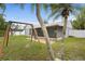 Scenic backyard view with a swing set, screened patio, and well-maintained lawn at 11619 Fox Creek Dr, Tampa, FL 33635