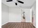 A bedroom showcasing neutral walls, wood floors, and a view into an adjacent tiled hallway at 11619 Fox Creek Dr, Tampa, FL 33635