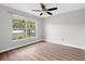 Bright bedroom featuring wood floors, ceiling fan, and a window with a lush, green view at 11619 Fox Creek Dr, Tampa, FL 33635
