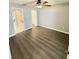 Neutral bedroom with a ceiling fan, wood-look flooring, and attached bathroom and closet at 11619 Fox Creek Dr, Tampa, FL 33635